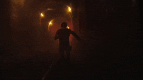 a blurry picture of a person in a dark room with a light shining on them .
