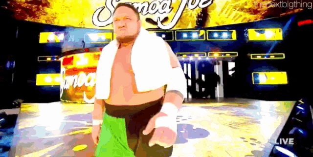 a wrestler with a towel around his neck stands in front of a sign that says smack down