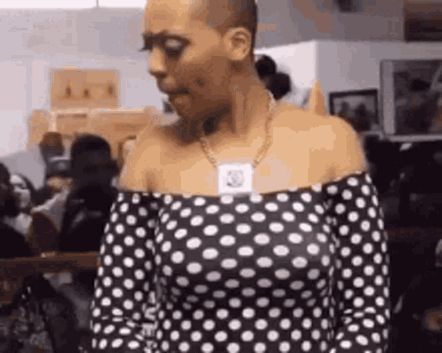 a woman wearing a black and white polka dot off the shoulder top .