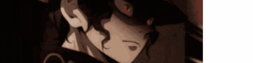 a close up of a person 's face in a dark room with a red eye .