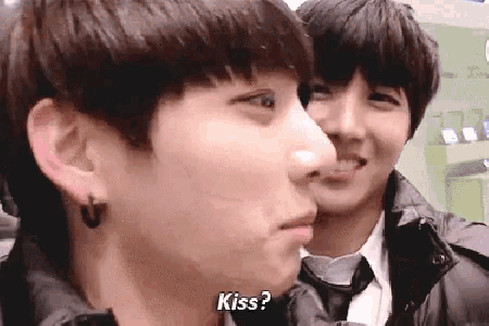 a man is kissing another man on the cheek while another man looks on .