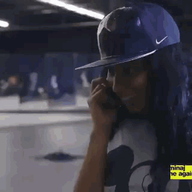 a man wearing a hat is covering his face with his hands and the words nicki minaj my time again are on the bottom right