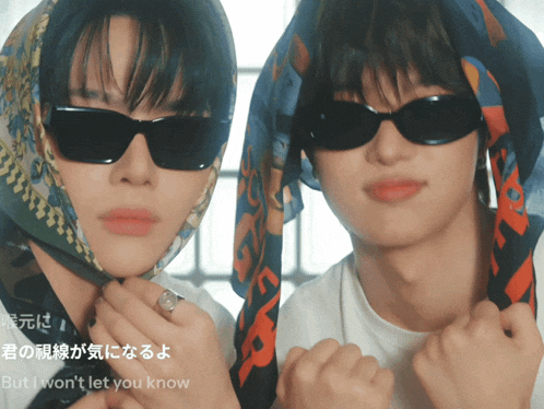 a man wearing sunglasses and a scarf around his head is next to another man wearing sunglasses and a scarf around his head