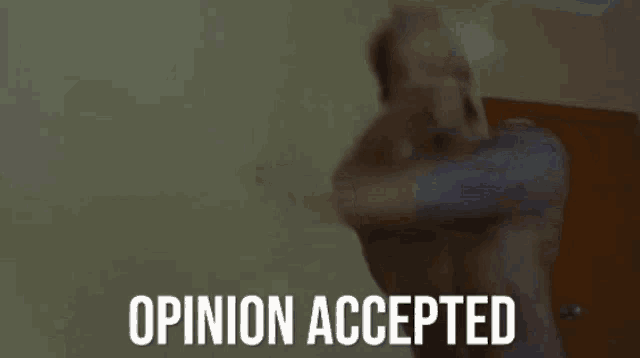 a man is standing in front of a wall with the words opinion accepted on it