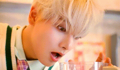 a close up of a person 's face with a glass in front of them .