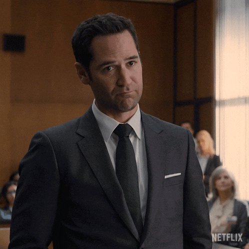 a man in a suit and tie is standing in front of a netflix ad