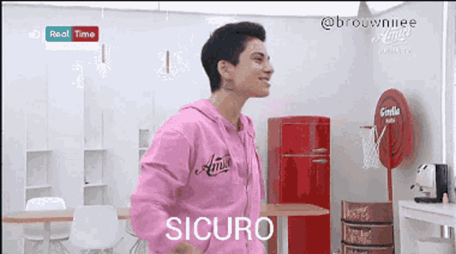 a man wearing a pink hoodie with the word sicuro on the front