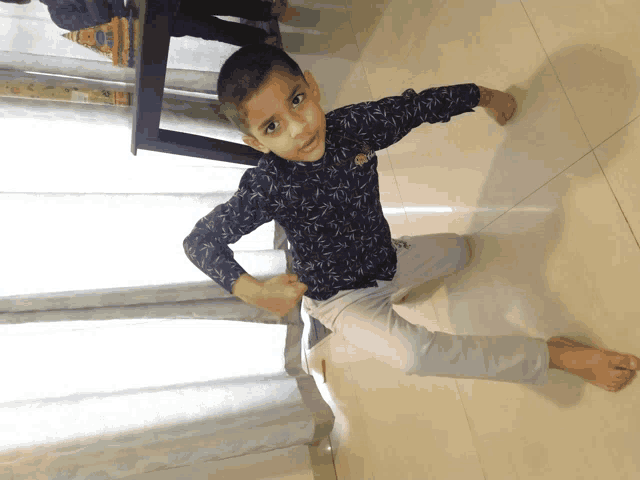 a young boy wearing a shirt that says ' disney ' on it is kneeling on the floor