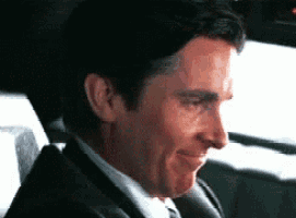 a man in a suit and tie is smiling in a car