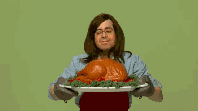a man in an apron is holding a turkey on a white plate