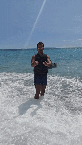 a man standing in the water making a heart shape