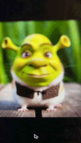 shrek is shown on a computer screen with a mouse behind him