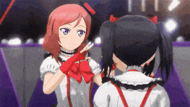 a couple of anime girls are standing next to each other .