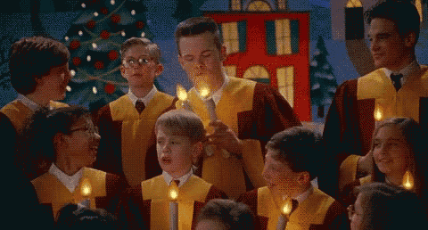a group of children are singing in a choir while holding candles