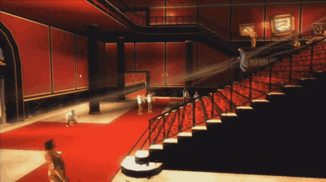 a group of people standing on a red carpet in a room with stairs