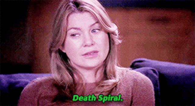 a woman is sitting on a couch talking to someone and the words death spiral are on the screen .