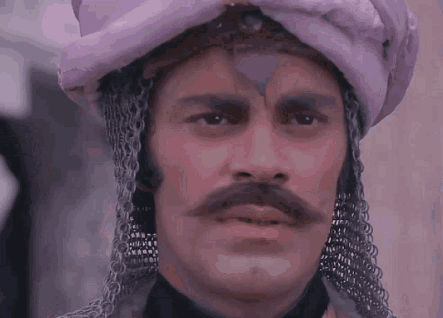 a man with a mustache wearing a purple turban