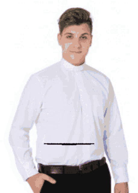 a man wearing a light blue shirt and black pants is standing with his hands in his pockets