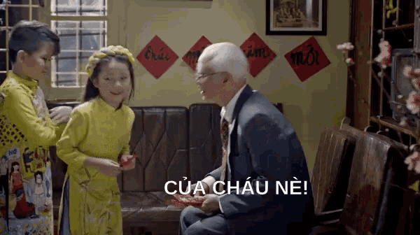 a man in a suit is sitting next to a little girl in a yellow dress and the words của châu ne are above him