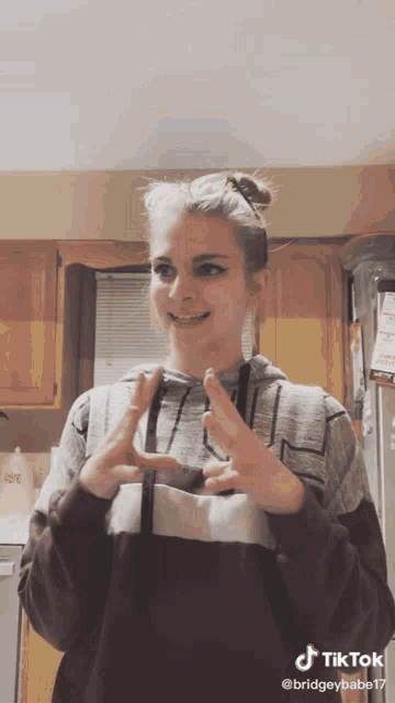 a woman is making a funny face in a kitchen with a tiktok watermark