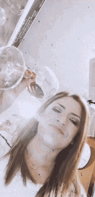 a woman is holding a glass of wine in her right hand
