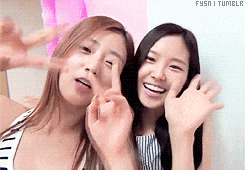 two women are making a peace sign with their hands while standing next to each other