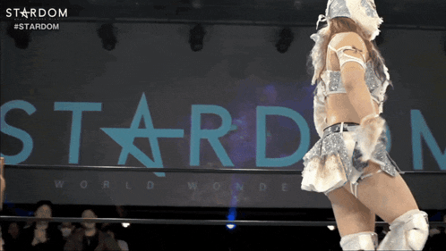 a female wrestler is standing in front of a stardom logo
