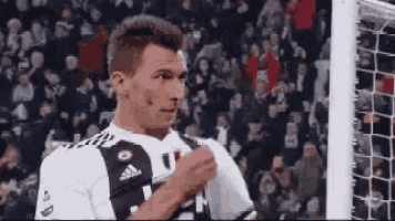 a soccer player is standing in front of a soccer goal .