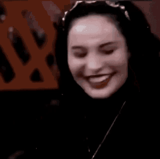 a woman with a headband on her head is smiling and laughing .