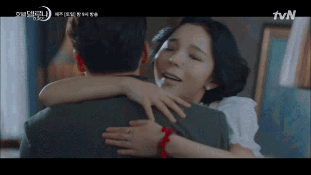 a woman is hugging a man with a tvn logo in the background