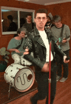 a man singing into a microphone in front of a drum that says sub-radio