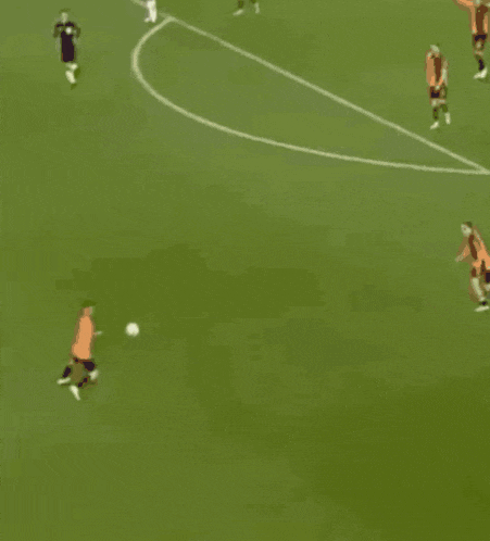 a group of soccer players on a field with one wearing an orange jersey
