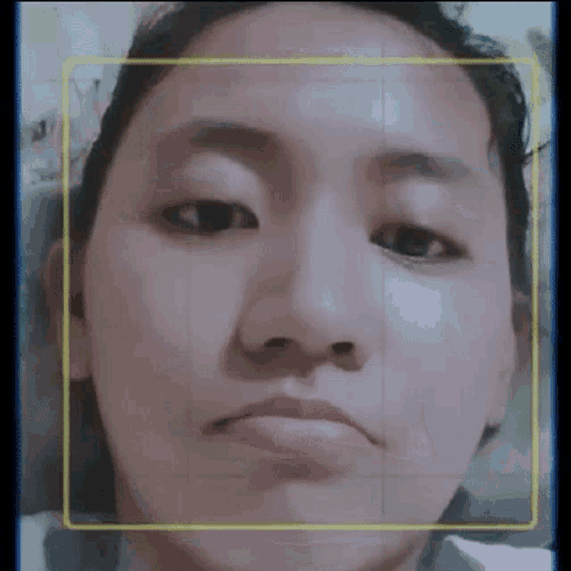 a close up of a woman 's face with a yellow border around her face .