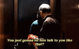 a man is talking to a woman in an elevator while holding a piece of meat in his hand .