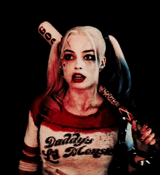 a woman in a daddy 's lil monster costume holding a bat
