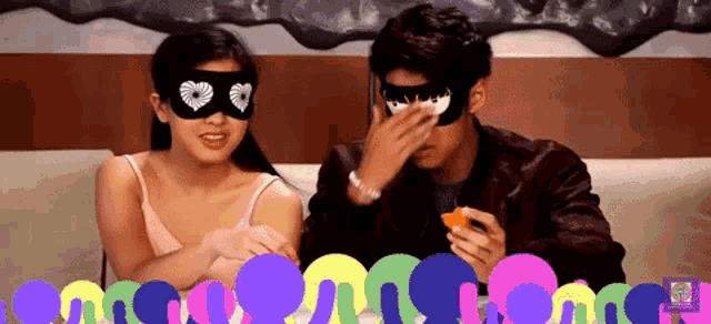 a man and a woman wearing masks sitting on a couch