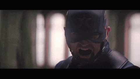 a close up of a man wearing a mask and a captain america hat .