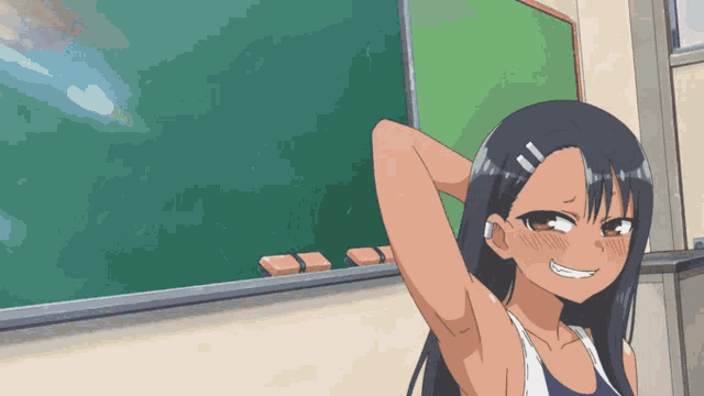 a girl in a blue tank top is standing in front of a green board