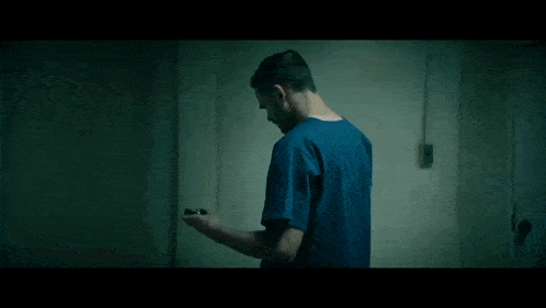 a man in a blue scrub top is holding a fireball in his hand .
