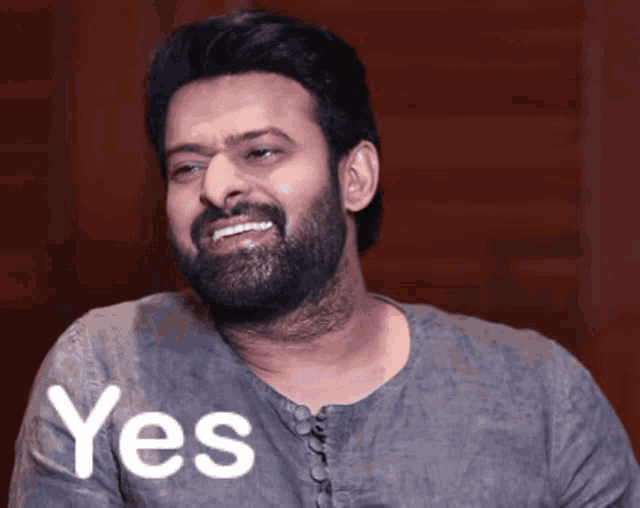 a man with a beard wearing a grey shirt that says yes on it