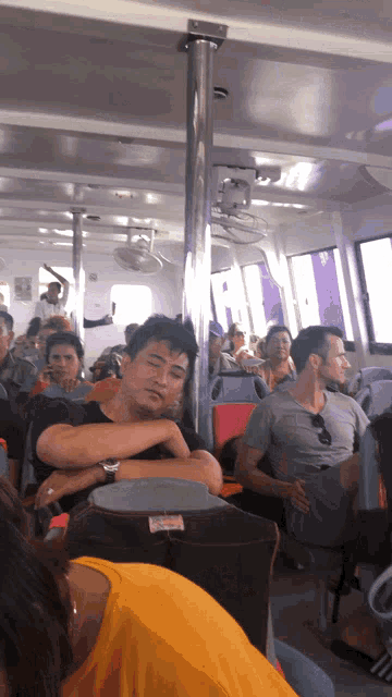 a group of people are sitting on a boat and one of them has a yellow shirt on