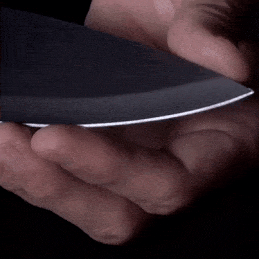 a person is holding a black knife in their hands