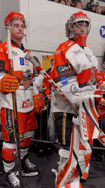 two hockey players wearing jerseys that say coors and ccm stand next to each other