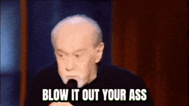 a man is speaking into a microphone and says blow it out your ass .
