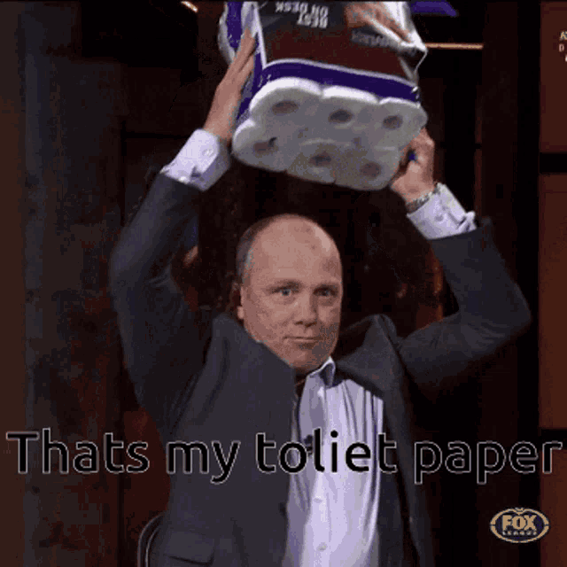 a man in a suit holds a roll of toilet paper over his head with the caption that 's my toilet paper