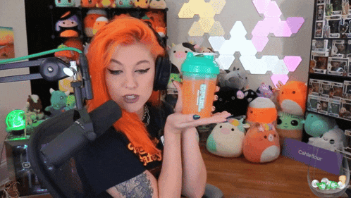 a woman with orange hair is holding a shaker that says shake it out