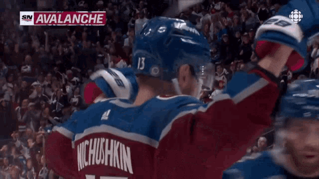 a hockey player wearing a number 22 jersey is celebrating a goal