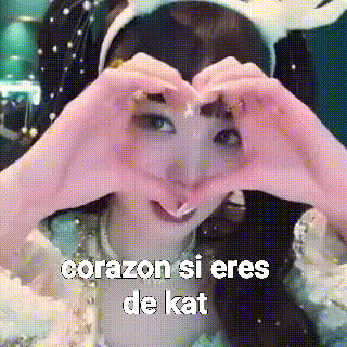 a woman is making a heart shape with her hands and the words corazon si eres de kat are above her