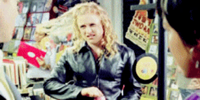 a woman in a leather jacket is talking to another woman in a store