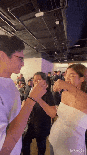 a man and a woman are standing next to each other at a party